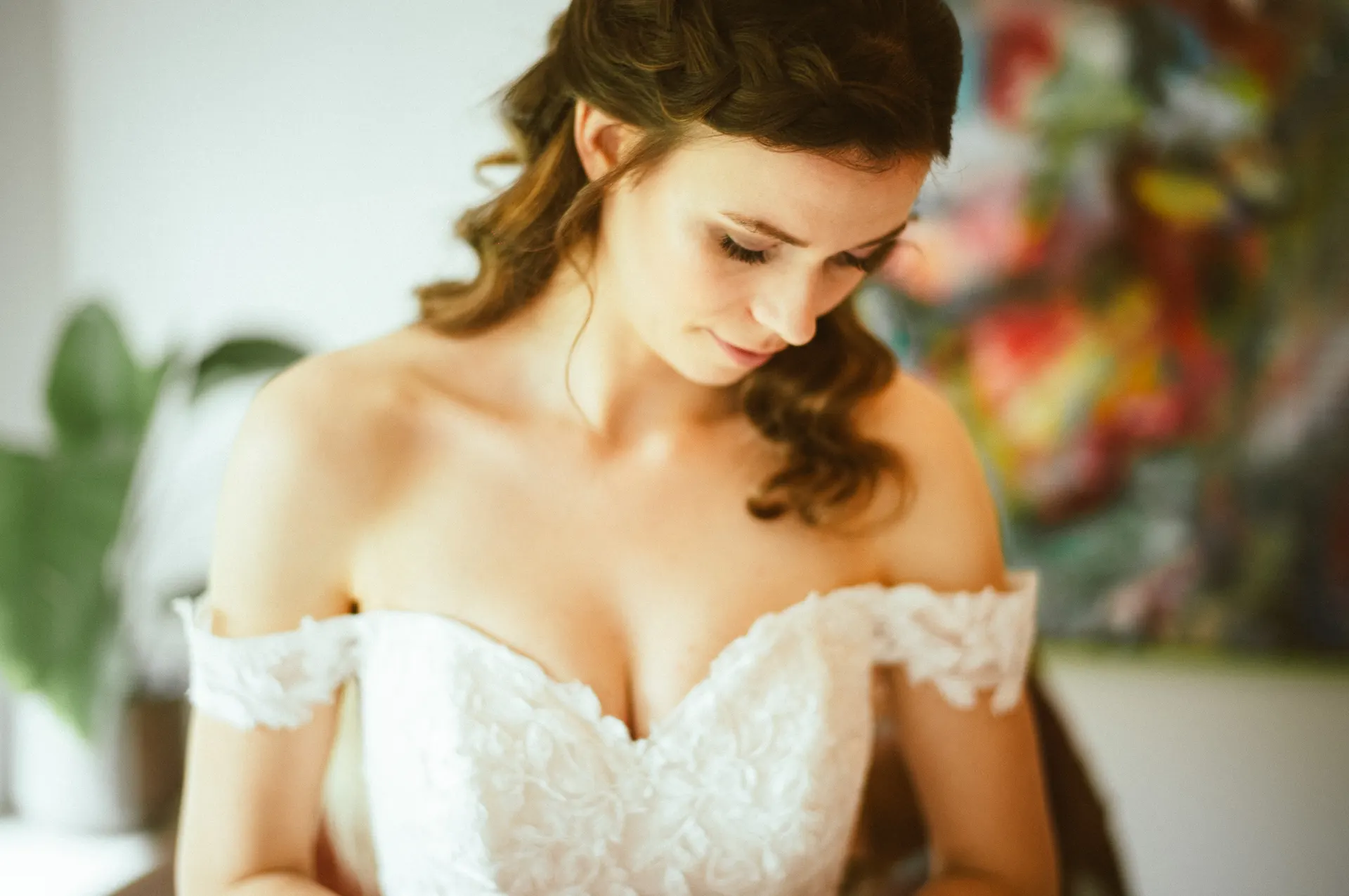 Bride in an off-shoulder wedding dress photographed in soft window light
